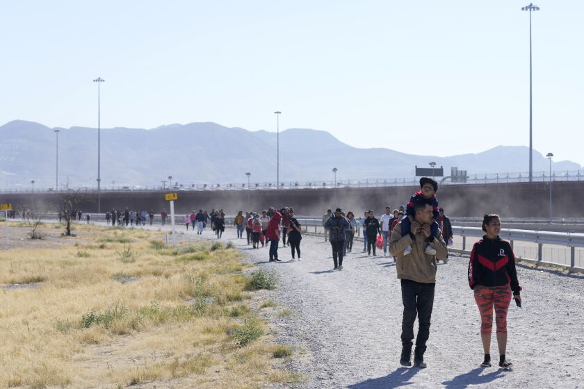 Migrants walk along the Mexico-U.S. border in Ciudad Juarez, Mexico, Wednesday, March 29, 2023, a day after dozens of migrants died in a fire at a migrant detention center in Ciudad Juarez. (AP Photo/Fernando Llano)