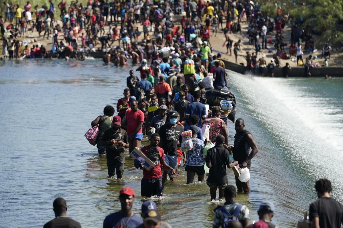 Migrantes haitianos usan una represa para cruzar entre México y Estados Unidos en Del Rio, Texas.