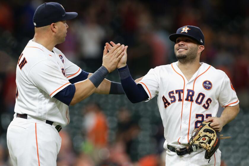 The Astros' Jose Altuve high-fives Carlos Beltran after the final out.