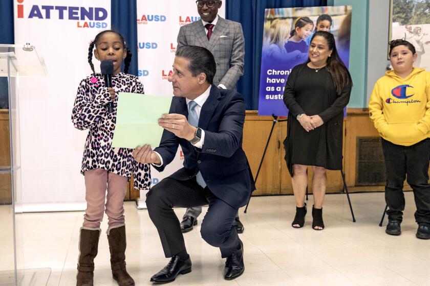 LOS ANGELES, CA-FEBRUARY 3, 2023:LAUSD Superintendent Alberto Carvalho holds a paper written by 4th grader Tinniya Wilson as she reads her prepared remarks addressing the media about the benefits of having a tutor and mentor during a press conference at Compton Ave. Elementary School STEAM Academy in Los Angeles. In background from left to right are Andre Spicer, LAUSD Region South Interim Superintendent, Denise Miranda, Ed.D. Director for LAUSD, and Michael Arrellano, a 4th grader at the school who also benefited from having a tutor. Carvalho announced a new mentoring initiative, Everyone Mentors LA, during the press conference. The mentoring initiative will invest in the lives of historically underserved students. It will match students contending with declining grades, chronic absenteeism, social emotional support and other challenges that have inhibited their academic success with a mentor from the Los Angeles community. (Mel Melcon / Los Angeles Times)