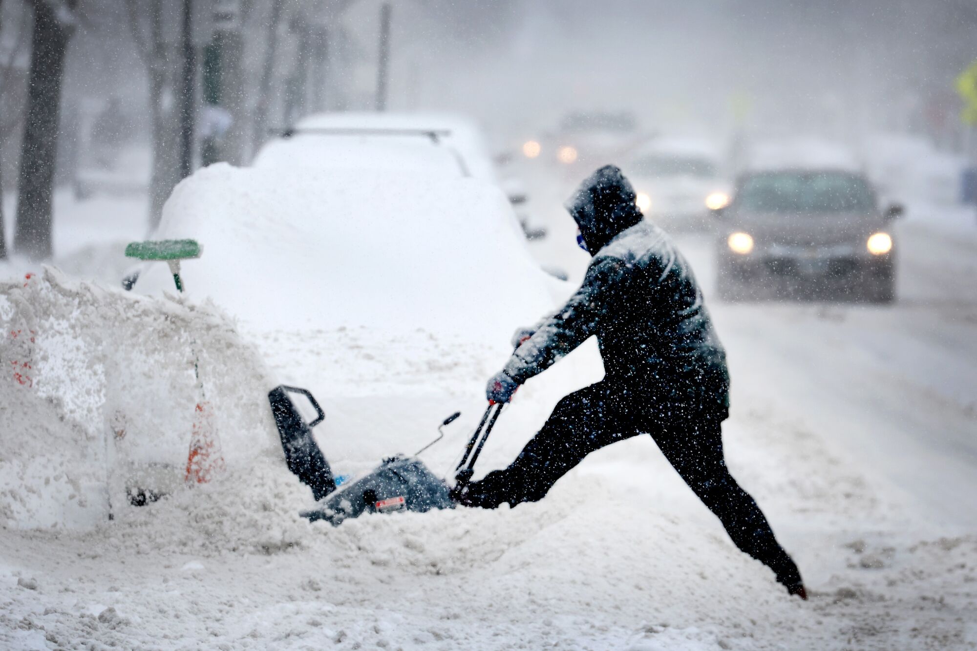 A resident digs out his car from heavy snow