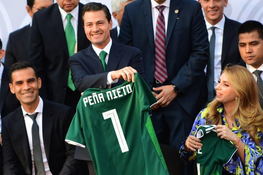Mexican President Enrique Pena Nieto (C) smiles next to Mexican player Rafael Marquez, after receiving the Mexican national football team jersey with his name, during a send-off ceremony at Los Pinos presidential residence in Mexico City on May 31, 2018, ahead of Mexico's last friendly match next June 2, against Scotland at the Azteca stadium, before the team departs to Copenhagen for the the last stage of their preparation ahead of the FIFA World Cup 2018. / AFP PHOTO / PEDRO PARDOPEDRO PARDO/AFP/Getty Images ** OUTS - ELSENT, FPG, CM - OUTS * NM, PH, VA if sourced by CT, LA or MoD **
