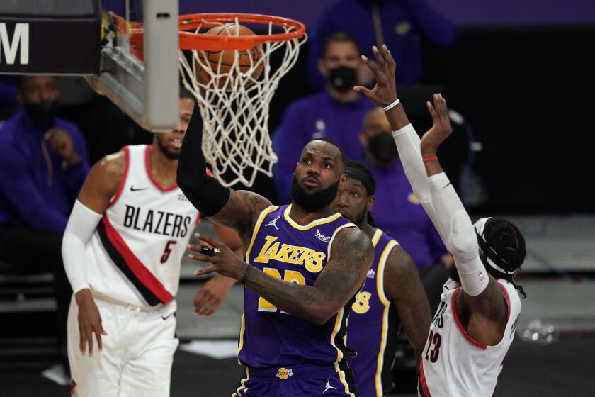 Los Angeles Lakers forward LeBron James, center, shoots against Portland Trail Blazers forward Robert Covington, right, during the first half of an NBA basketball game Friday, Feb. 26, 2021, in Los Angeles. (AP Photo/Mark J. Terrill)