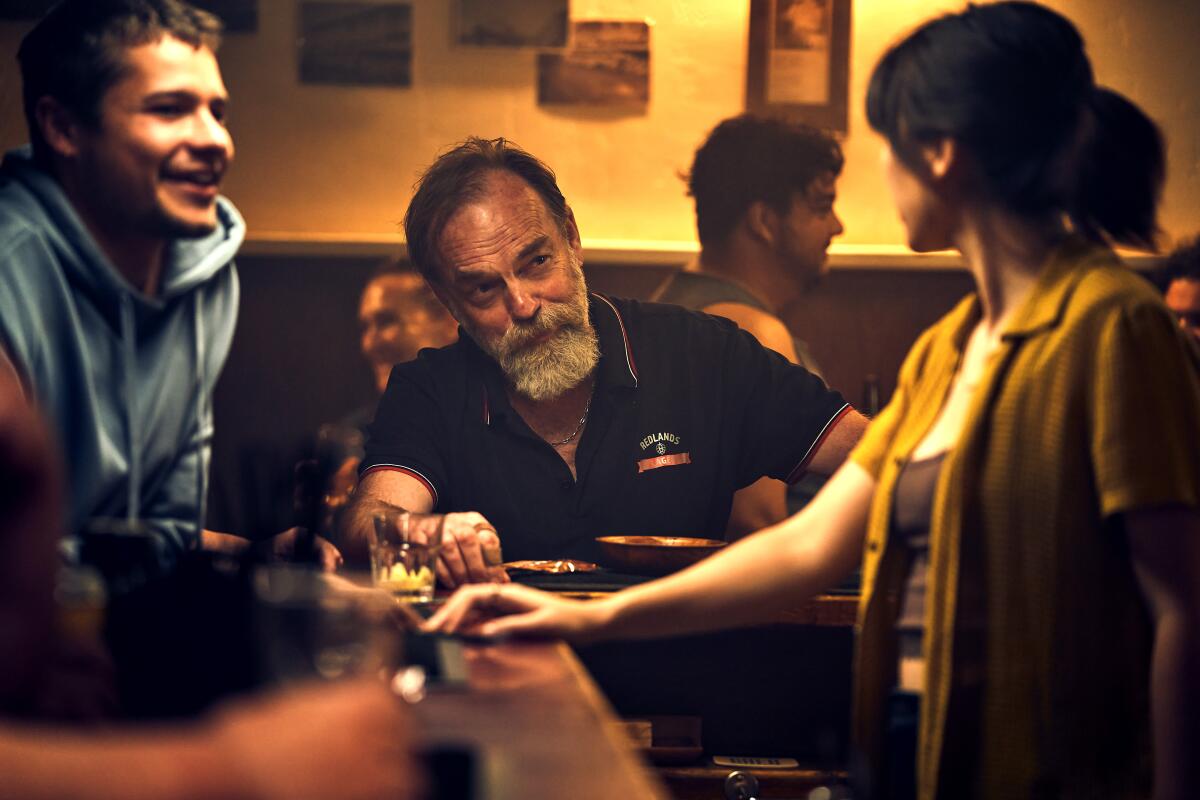 Leering men taunt a female bartender.