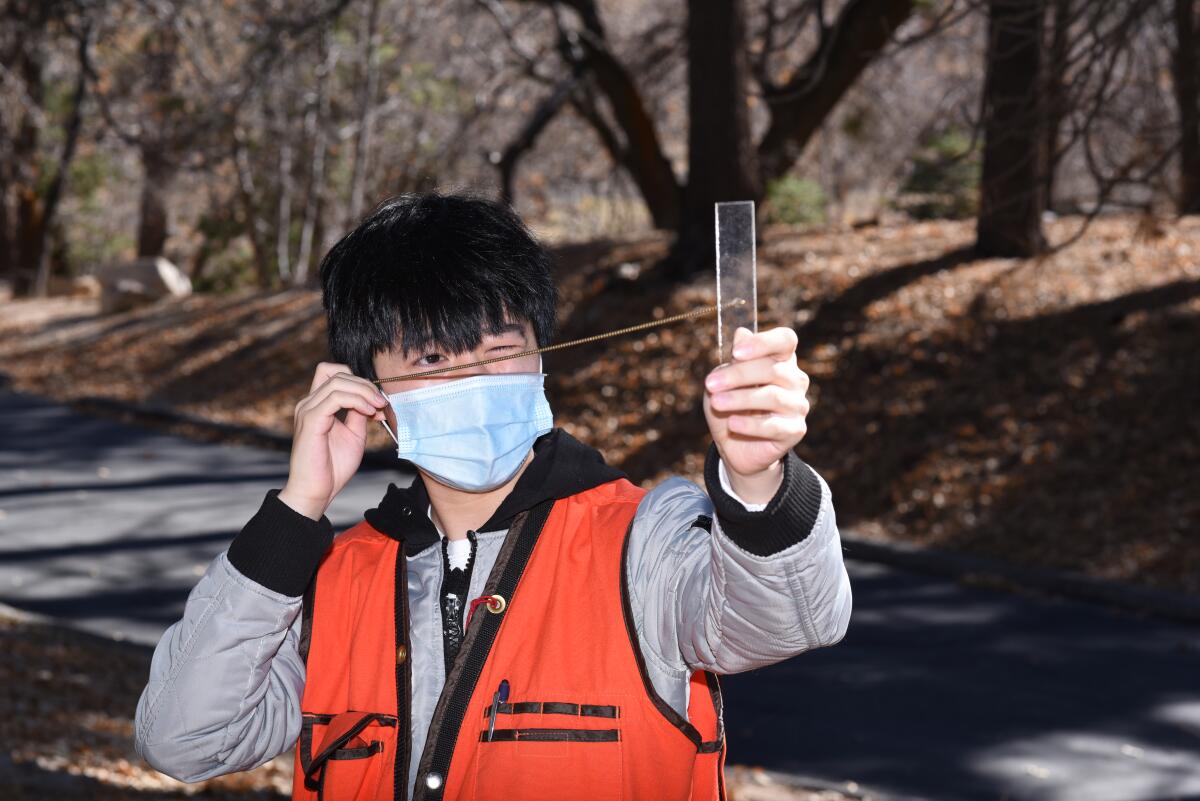 Tyler Do uses an angle gauge to determine forest density during the 2021 San Bernardino Forestry Challenge.