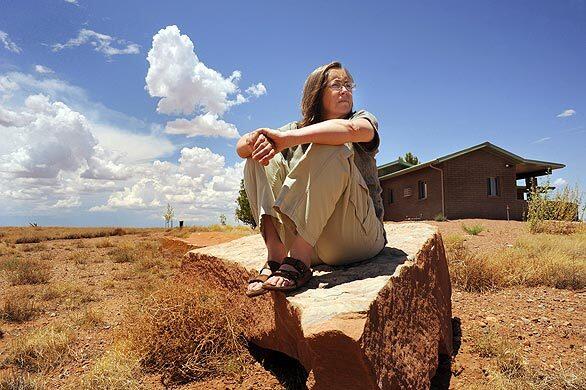 Kathy Hemenways home in Snowflake, Ariz., is a refuge from the gases, chemicals and electromagnetic fields that are nearly ubiquitous in our 21st century world. Her sensitivities to various chemicals began when she was just a kid. Hemenway relaxes on one of her favorite rocks outside of her "safe house" in Snowflake, Ariz. The house exterior is made of masonry blocks and a steel roof.