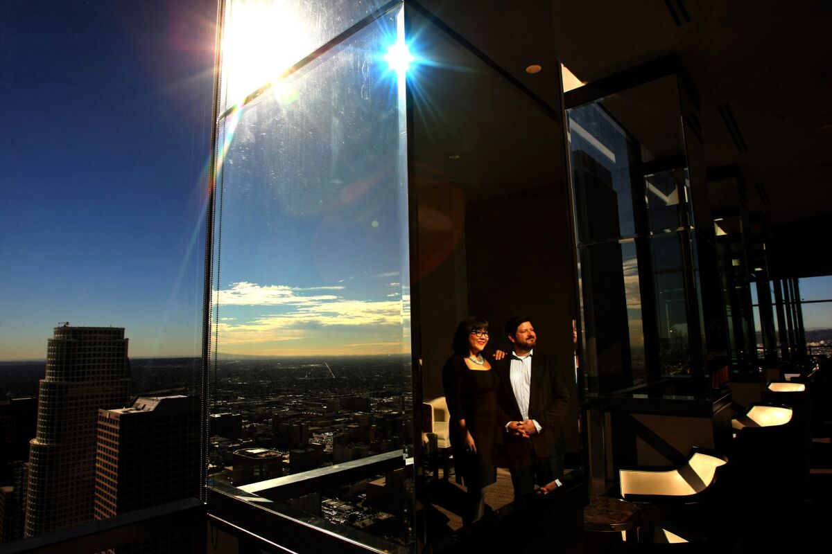 Members Sian and Todd Seligman, reflected in a column of mirrors, stand inside the City Club at its new location of the 51st floor of the City National Bank Building in downtown Los Angeles.