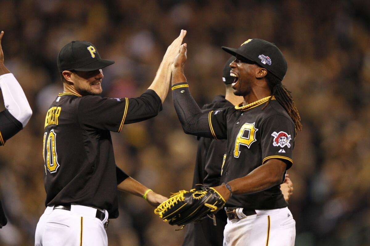 Jordy Mercer and Andrew McCutchen celebrate after the Pittsburgh Pirates' 6-2 victory over Cincinnati in the National League wild card game Tuesday night.