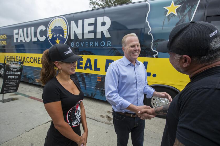 WHITTIER, CA - August 21,2021: Former San Diego Mayor Kevin Faulconer, center, greets the Chicken Koop owners Michelle Moreno, left, and husband Jay, right, during a campaign stop on his California Comeback Bus Tour in Whittier on Saturday, Aug. 21, 2021 in WHITTIER, CA. (Brian van der Brug / Los Angeles Times)