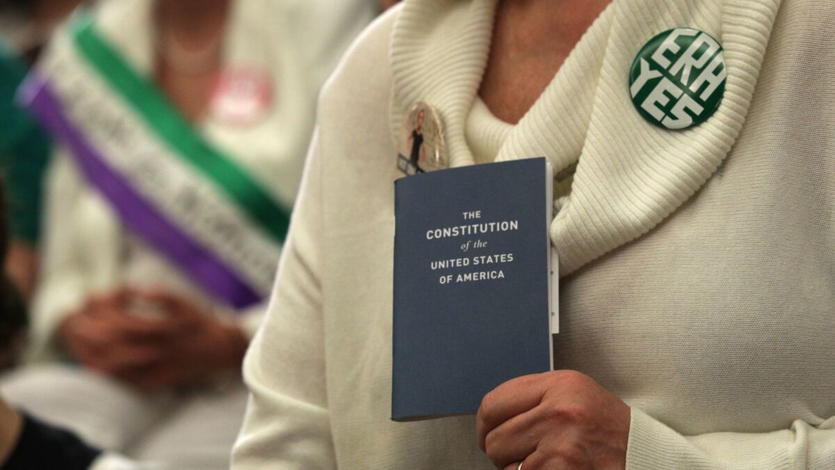 An advocate for ratification of the Equal Rights Amendment holds a copy of the U.S. Constitution