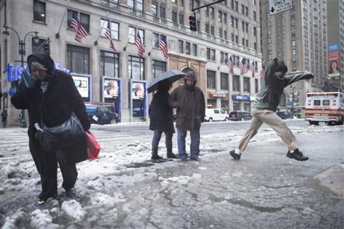 Pedestrians attempt to traverse slush puddles near Pennsylvania Station in New York.