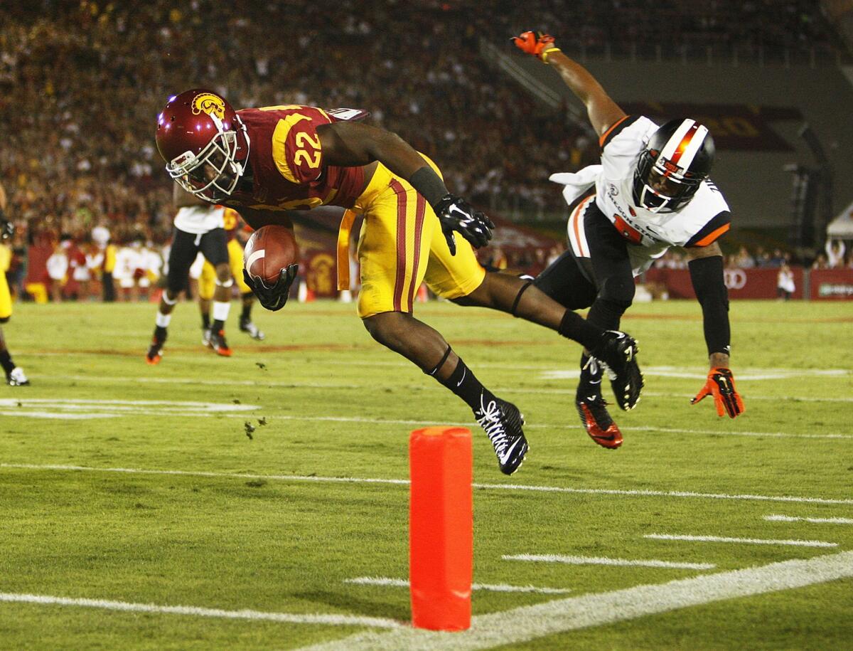 Beavers safety Tyrequek Zimmerman hits Trojans running back Justin Davis along the sideline but can't prevent him from reaching the goal line in the second quarter.