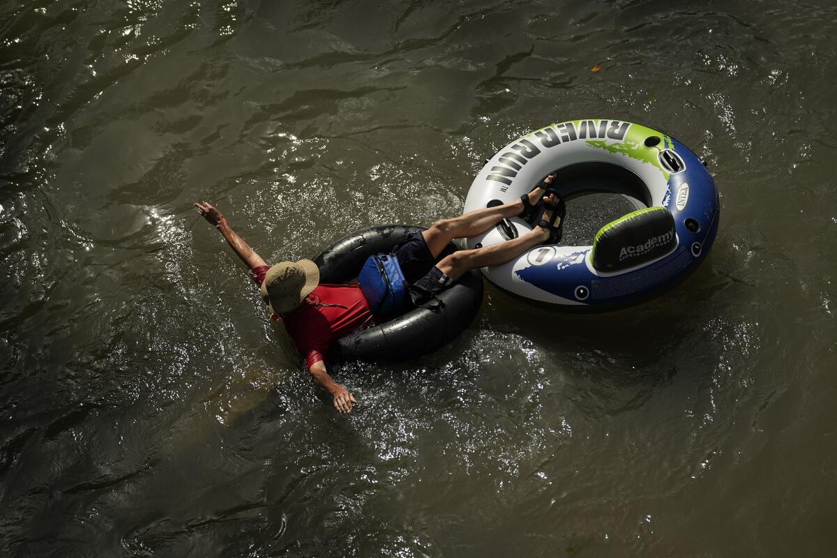 FILE - Overhead view of a person in an inner tube on water.