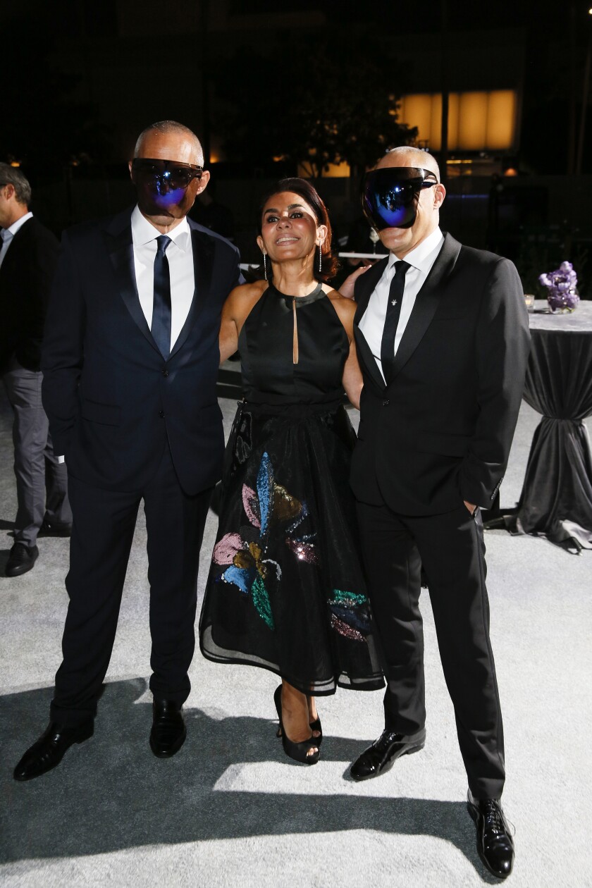 Anoosheh Oskouian is flanked by two masked guests during the 2021 OCMA Art Sense Gala.