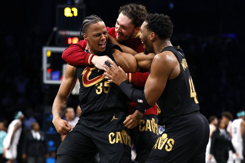 Cleveland Cavaliers forward Isaac Okoro celebrates with teammates Cedi Osman and Donovan Mitchell, right, after making the game winning shot against the Brooklyn Nets during the second half of an NBA basketball game, Thursday, March 23, 2023, in New York. The Cleveland Cavaliers won 115 - 109. (AP Photo/Noah K. Murray)
