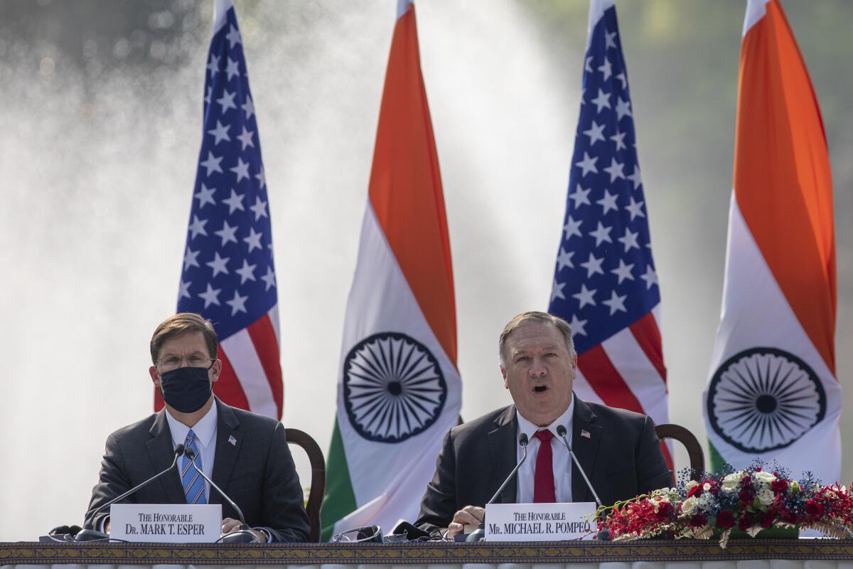 U.S. Secretary of State Mike Pompeo, right, speaks with Secretary of Defence Mark Esper seated beside him during a joint press conference with their Indian counterparts at Hyderabad House in New Delhi, India, Tuesday, Oct. 27, 2020. With President Donald Trump in a tight race for a second term against former Vice President Joe Biden, Pompeo and Esper sought to play on Indian suspicions about China to shore up a regional front against increasing Chinese assertiveness in the Indo-Pacific region. (AP Photo/Altaf Qadri)