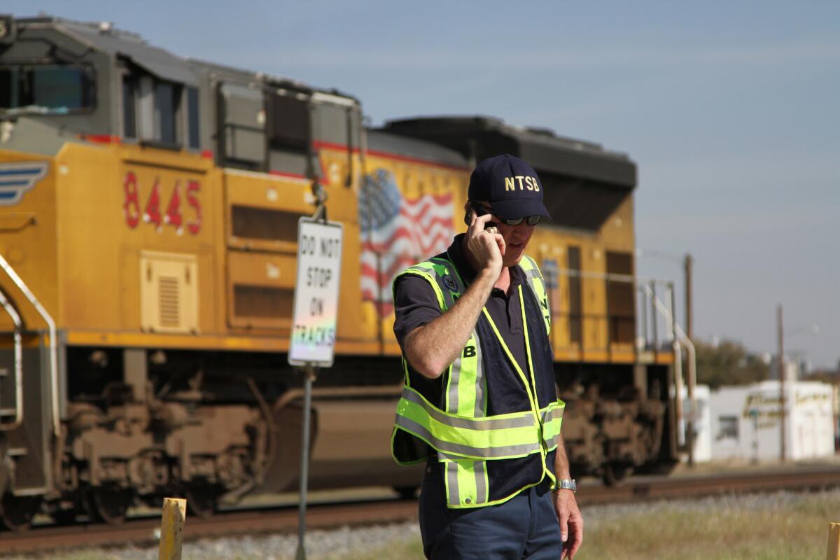 A railroad investigator talks on the phone on Nov. 17, 2012, at the scene of an accident two days earlier in which four veterans were killed and 16 other people were injured when a train slammed into a parade float carrying the returning heroes to a banquet in Midland, Texas.