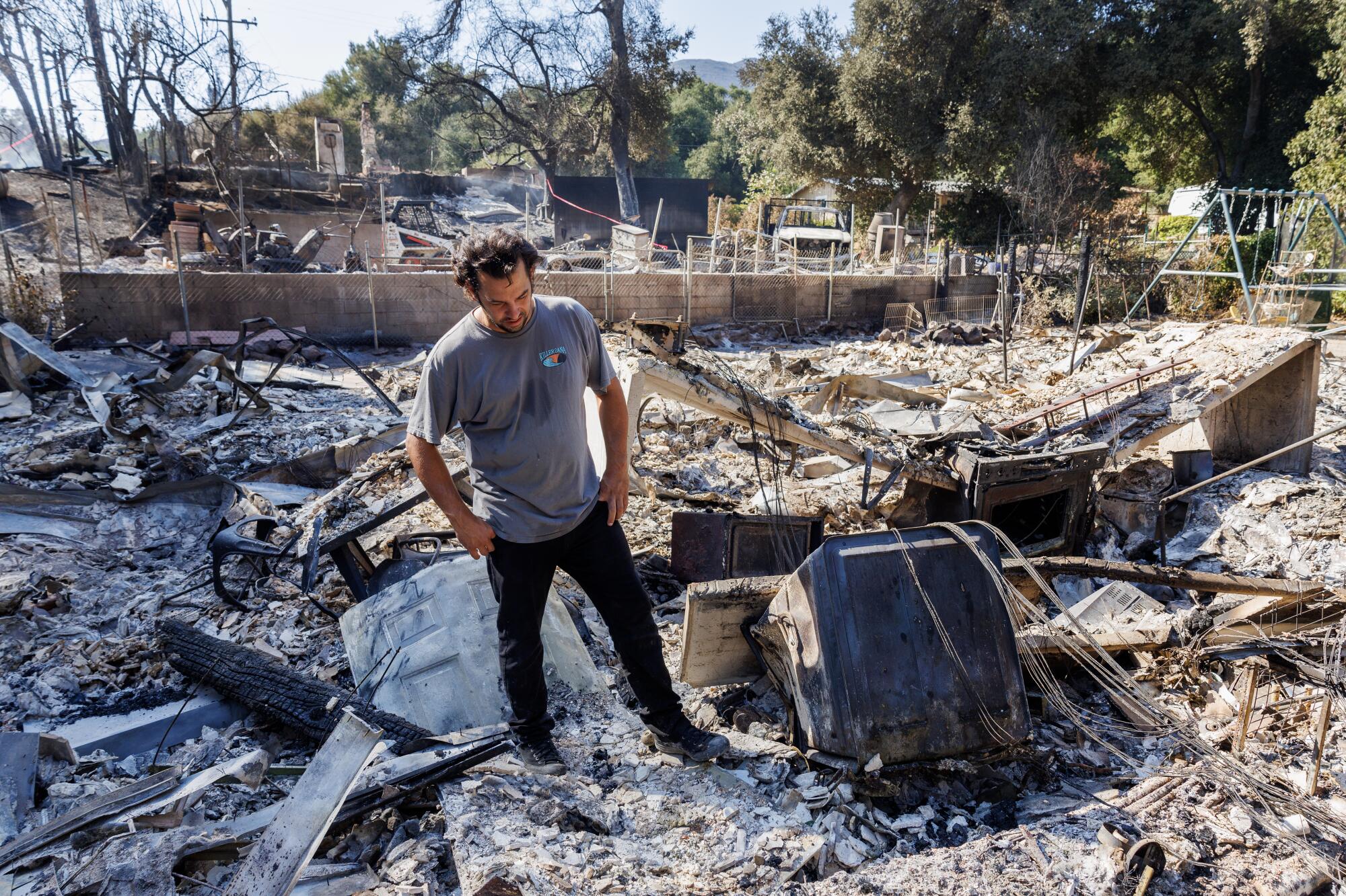 Resident Garrett Keene stands in the rubble of his home that was destroyed in the airport fire.