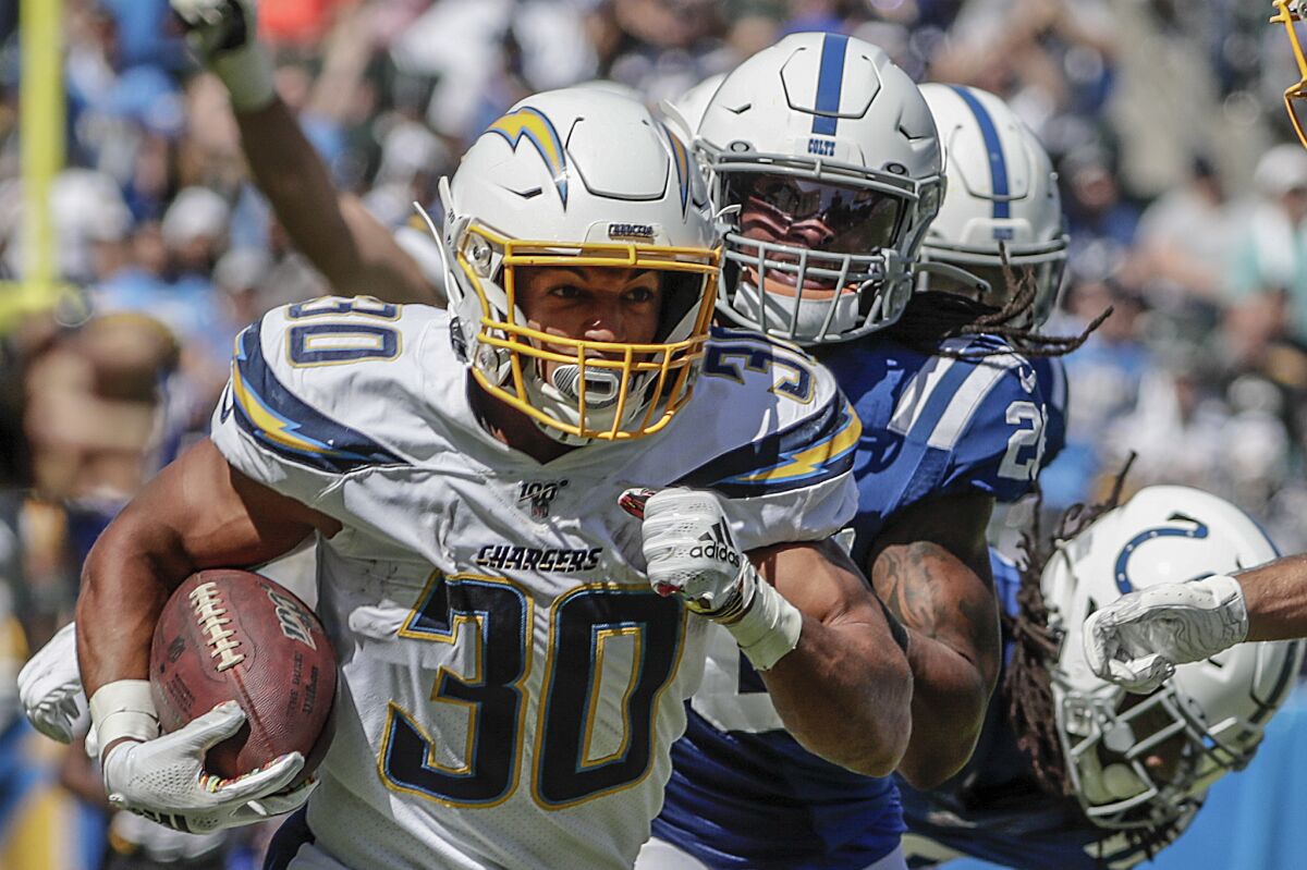 Chargers running back Austin Ekeler races past Colts defenders.