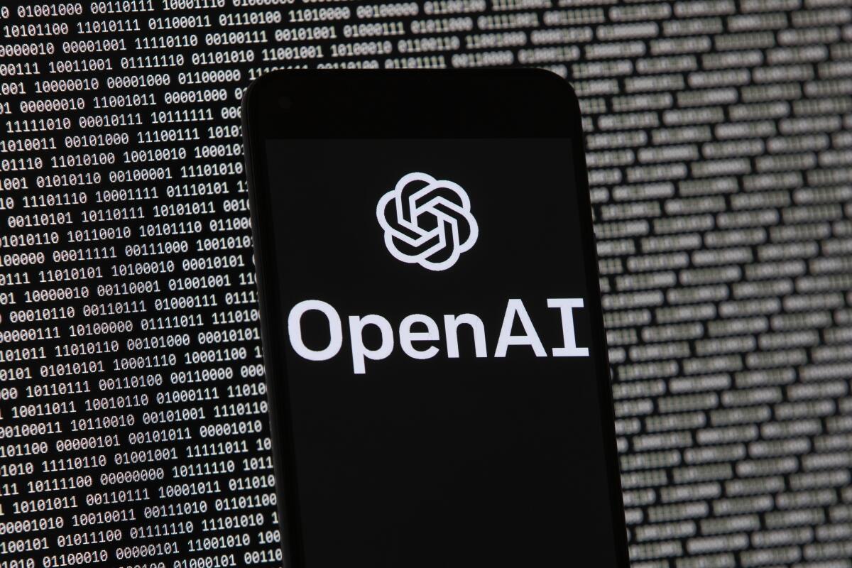 En esta imagen de archivo, el logo de OpenAI visto en un celular situado delante 