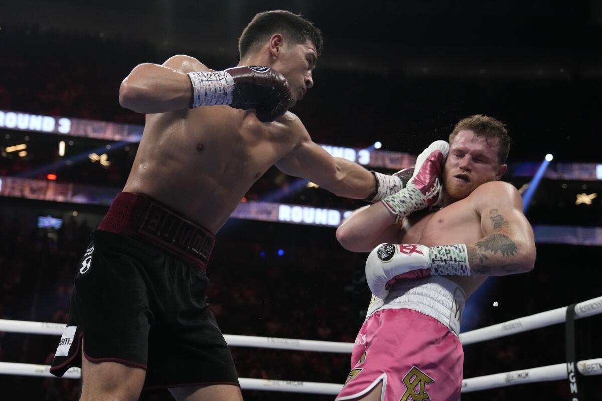Dmitry Bivol punches Canelo ?lvarez during a boxing match