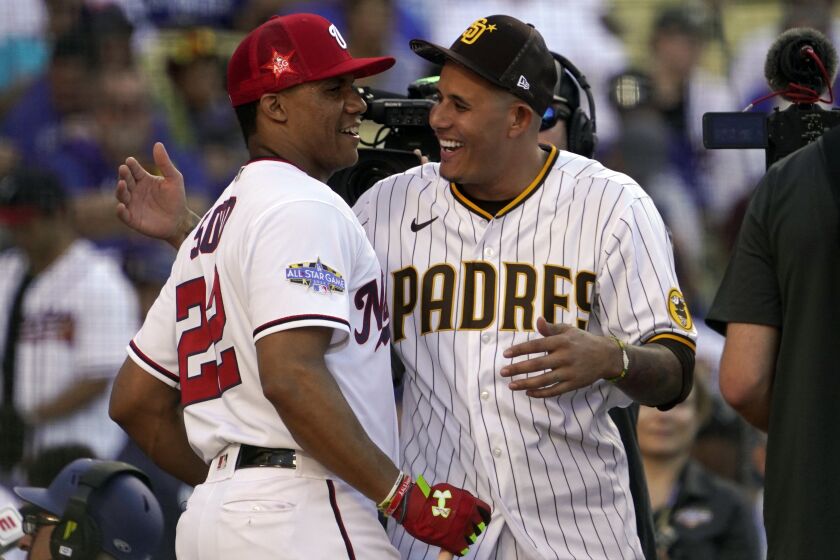 National League's Juan Soto, of the Washington Nationals, left, gets a hug from San Diego Padres' Manny Machado during the MLB All-Star baseball Home Run Derby, Monday, July 18, 2022, in Los Angeles. (AP Photo/Mark J. Terrill)