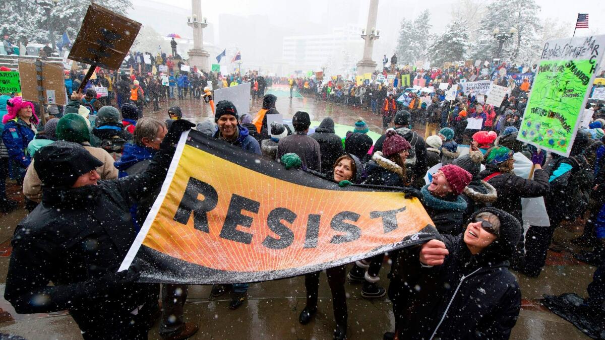Thousands of demonstrators gather at Civic Center Park for the People's Climate March during a spring snow storm in Denver.