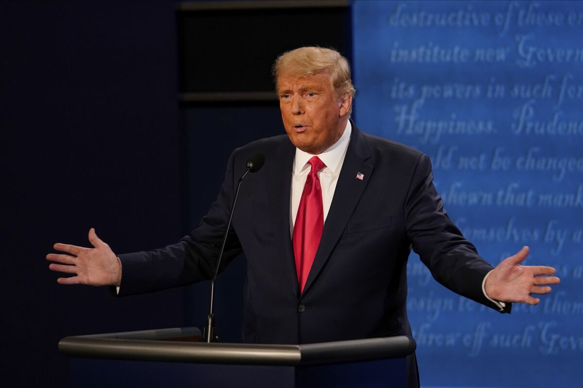 President Trump holds his arms wide as he answers a question at the final presidential debate.