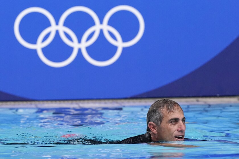 United States head coach Adam Krikorian swims in the pool following his team's win over Spain in the women's water polo gold medal match at the 2020 Summer Olympics, Saturday, Aug. 7, 2021, in Tokyo, Japan. (AP Photo/Mark Humphrey)