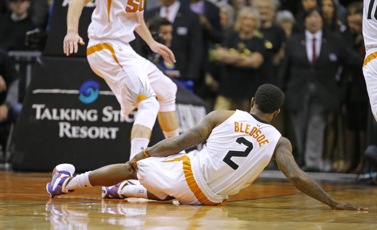 Suns guard Eric Bledsoe (2) grabs his leg after falling to the floor after being injured in the first half.