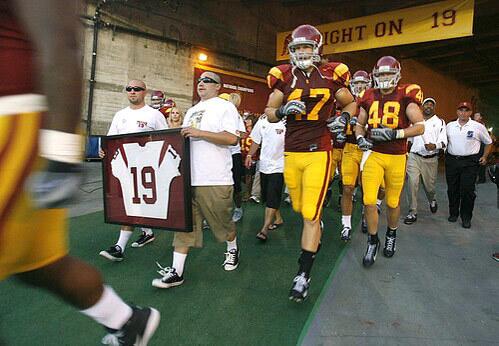 The jersey of Mario Danelo is carried out of the tunnel as the Trojans team takes the field before Saturday's game at the Coliseum. Danelo's body was discovered in January at the bottom of a cliff not far from his family's home in San Pedro. The Los Angeles County Dept. of Coroner said in a February autopsy report that Danelo was under the influence of alcohol and that the manner of death was undetermined.