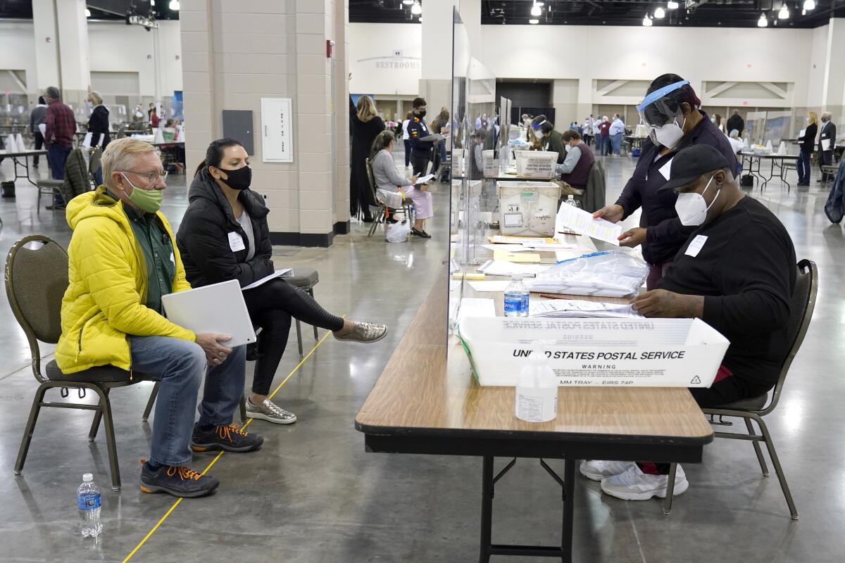 Election workers verify ballots, right, as observers watch in Milwaukee on FridayNam Y. Huh)