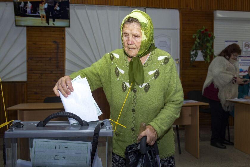 An elderly woman casts her ballot during a referendum in Luhansk, Luhansk People's Republic controlled by Russia-backed separatists, eastern Ukraine, Monday, Sept. 26, 2022. Voting began last Friday in four Moscow-held regions of Ukraine on referendums to become part of Russia. (AP Photo)