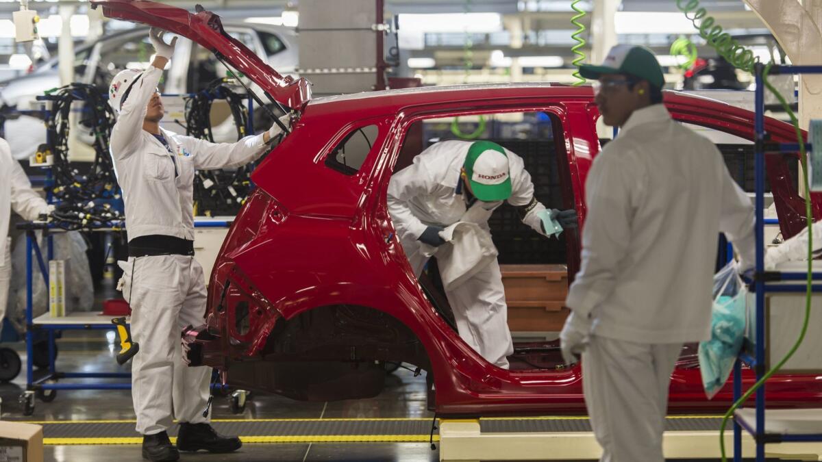 Workers build a vehicle on a Honda Motors factory assembly line in Celaya, Mexico, in 2014.