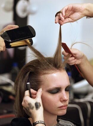 A model has her hair and makeup styled before designer Monique Lhuillier's Spring / Summer 2010 collection.