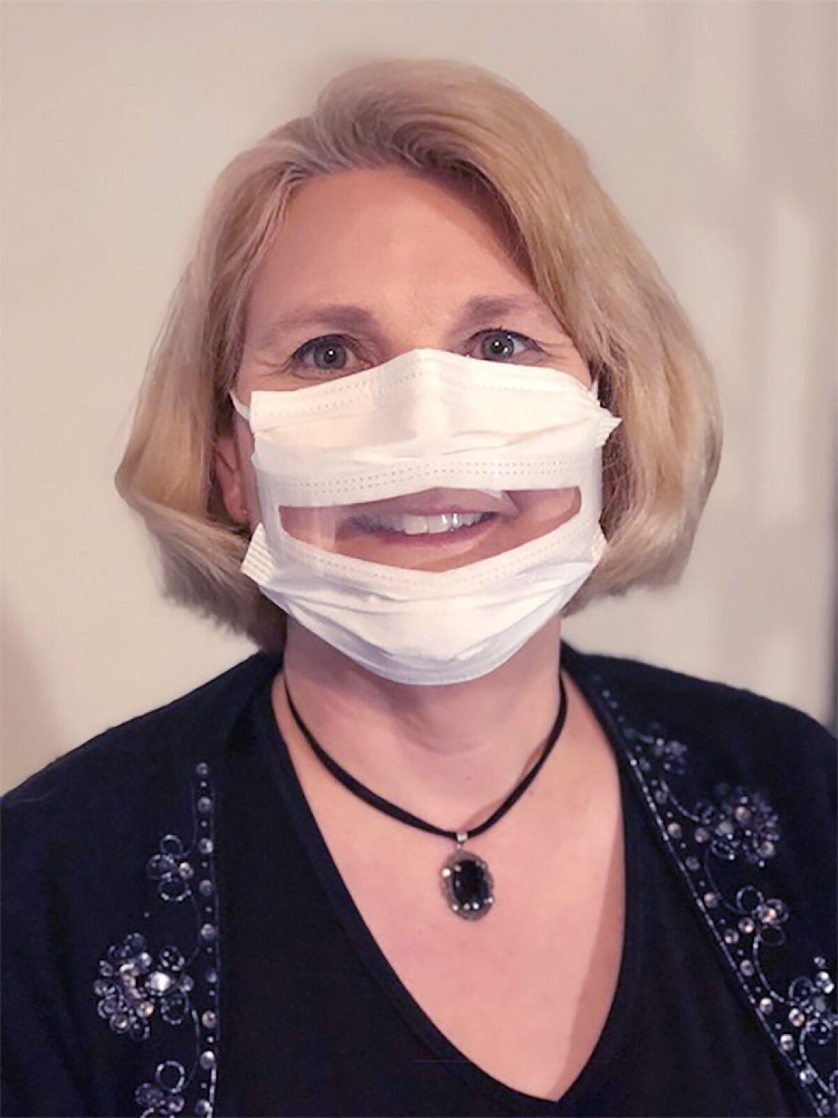 Anne McIntosh, president of Safe'N'Clear, wears the Communicator, an FDA-approved mask with a transparent window.