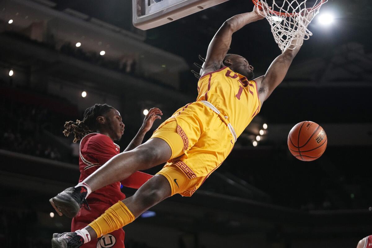 USC guard Isaiah Collier, right, dunks over Utah guard Deivon Smith during the first half.