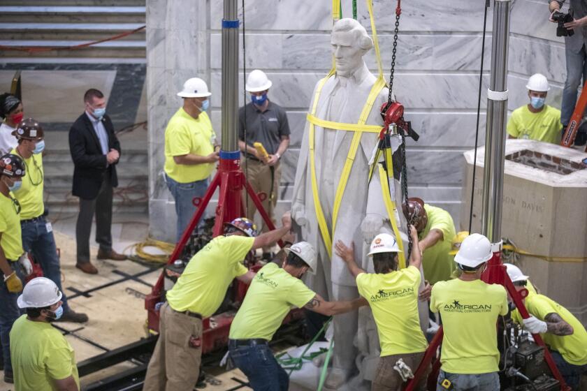 Workers prepare to remove the Jefferson Davis statue from the Kentucky state Capitol in Frankfort, Ky., on Saturday, June 13, 2020. A Kentucky commission voted to take down a statue of Confederate President Jefferson Davis from the state Capitol. The panel supported a push from the governor as the country faces protests against police brutality following the deaths of African Americans in encounters with police. (Ryan C. Hermens/Lexington Herald-Leader via AP)