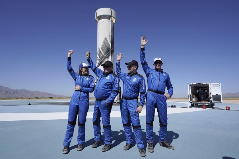 Los más recientes pasajeros espaciales del cohete New Shepard de Blue Origin, de izquierda a derecha Audrey Powers, William Shatner, Chris Boshuizen y Glen de Vries, levantan la mano mientras hablan a la prensa en el puerto espacial cerca de Van Horn, Texas, el miércoles 13 de octubre de 2021. (Foto AP/LM Otero)