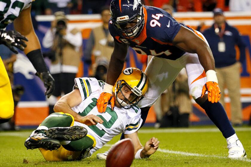 Broncos linebacker DeMarcus Ware (94) sacks Green Bay Packers quarterback Aaron Rodgers (12), leading to a fumble and safety Sunday.