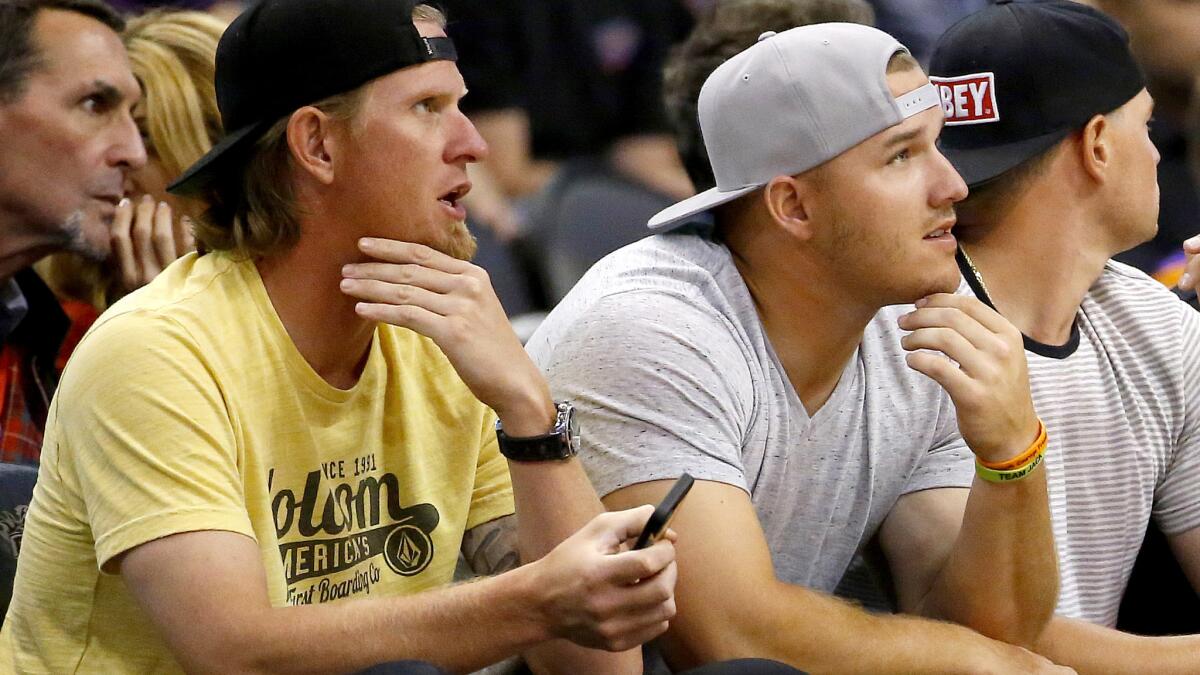 Angels pitcher Jered Weaver and center fielder Mike Trout watch the Lakers play the Suns in Phoenix on March 23.