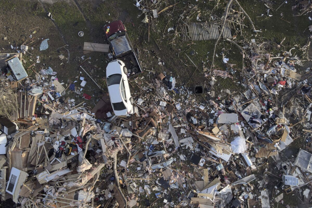 A car sits on top of debris after a tornado.
