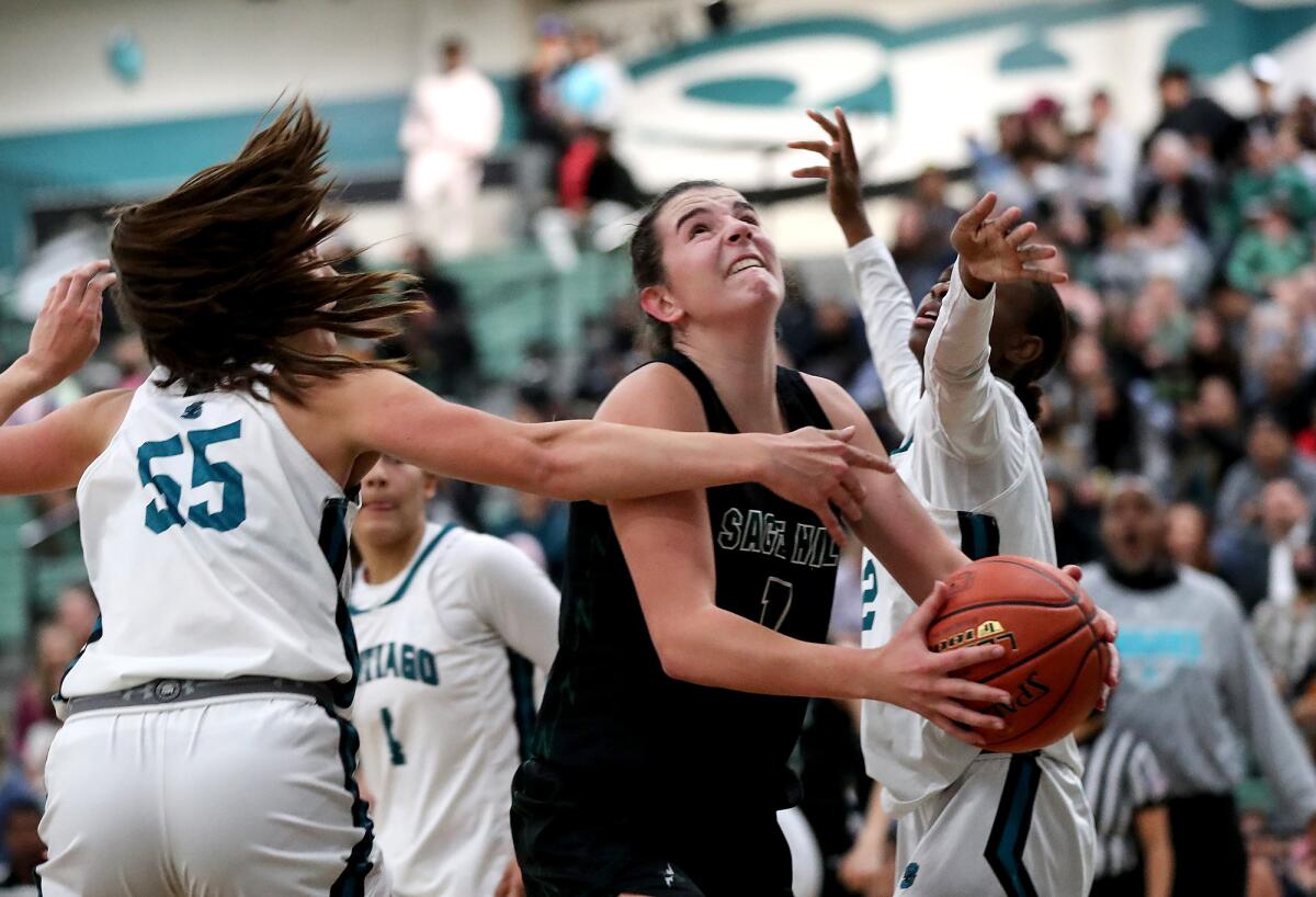 Sage Hill's Emily Eadie (1) drives between Corona Santiago's McKinley Willardson (55) and Tierra Taylor for a tough layup.