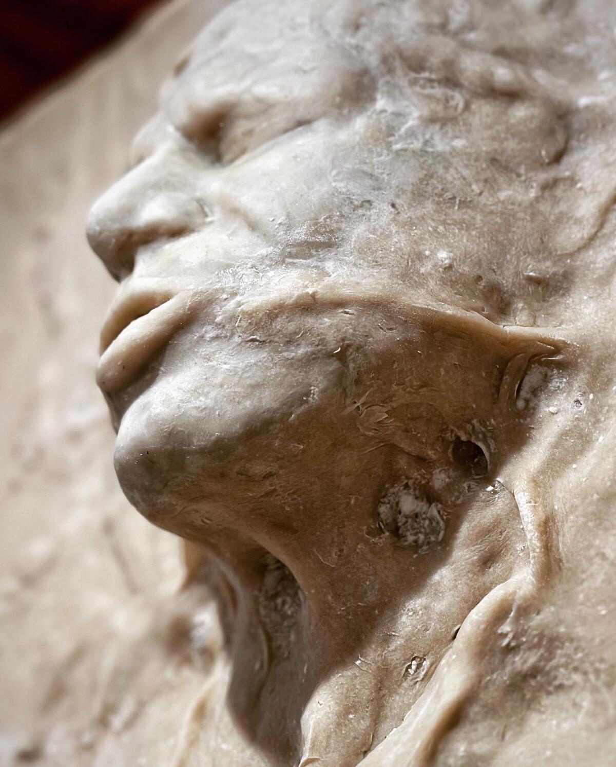 A bread sculpture depicting a man's anguished features 