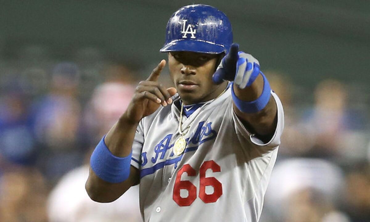 Dodgers right fielder Yasiel Puig points to the dugout after hitting a double against the Arizona Diamondbacks on Sept. 18. A rebroadcast of Puig's first major league game last June will be televised on SportsNet LA.