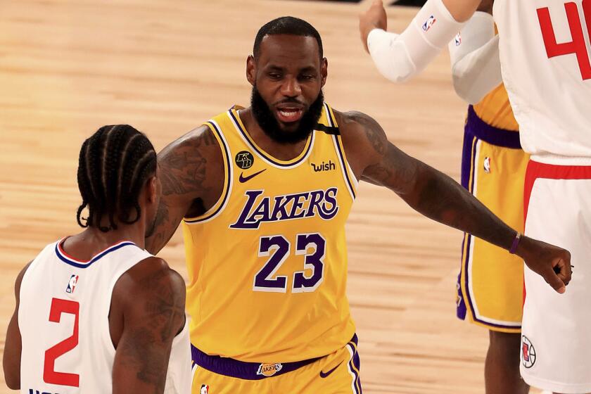 Los Angeles Lakers' LeBron James (23) talks with Los Angeles Clippers' Kawhi Leonard.