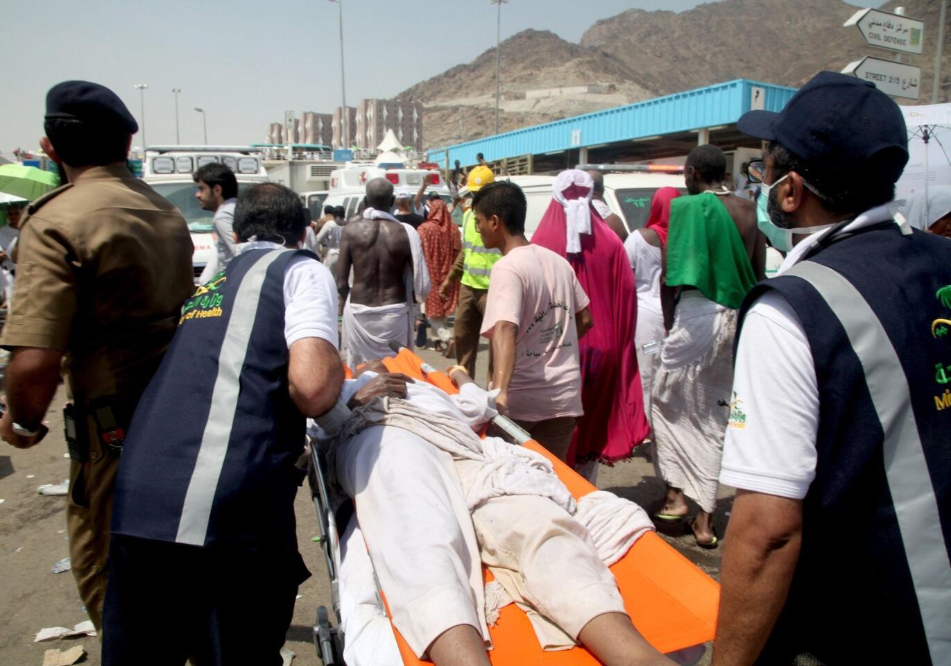 Saudi emergency personnel transport a hajj pilgim on a stretcher at the site of a stampede in Mina.