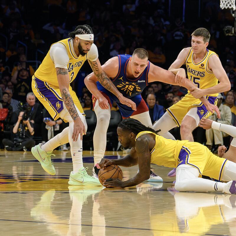 El alero de los Lakers, Taurean Prince, abajo, busca un balón suelto.