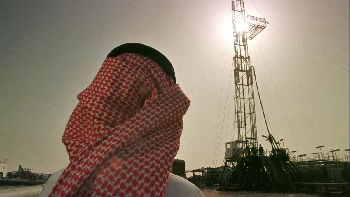 Khaled Otaibi, an official at the Saudi oil company Aramco, watches an oil rig at the Howta oil field in Saudi Arabia.