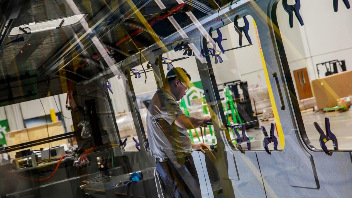 Proterra worker Manny Almanza builds out a bus interior. (Marcus Yam / Los Angeles Times)